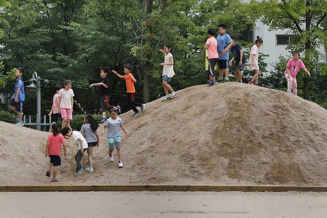 어린이들의 의견을 적극 반영해 서울 중랑구 신현초 운동장에 꾸민 서울시교육청의 학교 놀이터 혁신 제1호 '꿈을 담은 놀이터 같이 놀래'가 11일 개장식을 열어 문을 열었다. 완공된 바람의 언덕에서 학생들이 뛰어 놀고 있다. 이정아 기자 leej@hani.co.kr