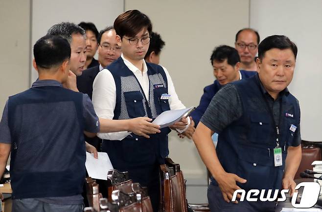 2019년도 최저임금이 8350원으로 확정됐다. 한국노총 소속 근로자위원들이 14일 정부세종청사 고용노동부 내 최저임금위 전원회의장에서 열린 15차 전원회의를 마친 뒤 결과에 불만족스러워 하고 있다. 재적인원 27명 중 사용자위원과 민주노총 소속 근로자위원을 재외한 14명이 근로자위원안 8680원과 공익위원안 8350원을 투표한 결과 8표를 얻은 공익위원안 8350원이 최종 확정됐다. 2018.7.14/뉴스1 © News1 장수영 기자