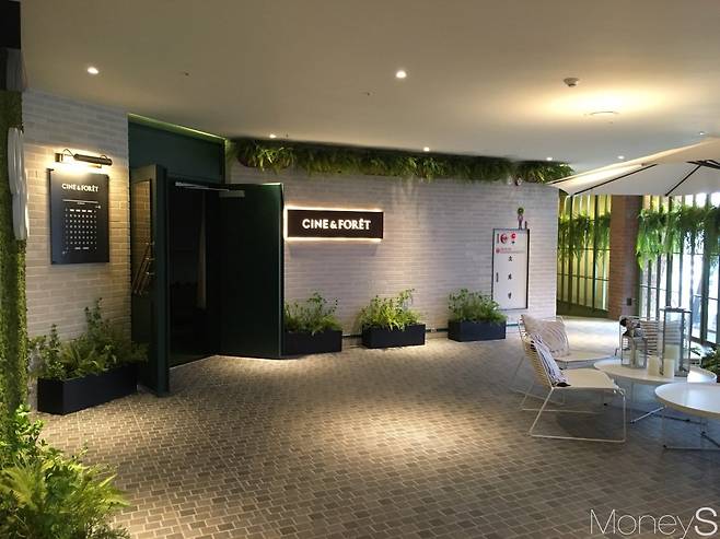 씨네앤포레 상영관 입구. 초록 식물과 네온사인, 피크닉 소품들로 꾸며져 있다. /사진=김경은 기자