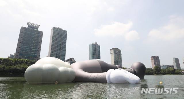 【서울=뉴시스】김선웅 기자 = 19일 오후 서울 송파구 석촌호수에 롯데와 송파구가 함께한 팝 아티스트 '카우스(KAWS)'의 공공 미술 프로젝트 '카우스:홀리데이 코리아(KAWS:HOLIDAY KOREA)'가 전시되고 있다. ‘카우스:홀리데이(KAWS:HOLIDAY)’는 길이 28M(세로), 25M(가로), 5M(높이)의 독창적인 캐릭터를 활용해 ‘일상으로부터 탈출해 모든 것을 잊고 세상을 바라보며 휴식을 취하는 모습’을 표현한다. 전시는 다음달 19일까지 관람할 수 있다. 2018.07.19. photo@newsis.com