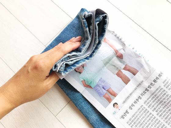 청바지를 세로로 반 접어 놓고 사이에 신문지를 넣는다. 다음은 발목부터 위쪽으로 둘둘 말아 올린다.