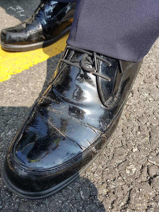 서울 강남역 인근에서 근무 중인 한 교통경찰이 “단화(근무화)가 녹았다”면서 옆면에 구멍이 난 단화를 보여주고 있다. 유영재 기자 young@seoul.co.kr