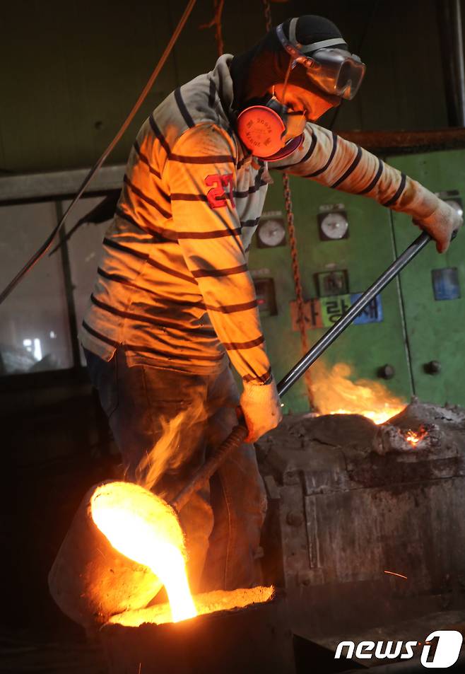 29일 경북 구미시 고아읍 사랑채 가마솥공장에서 스리랑카에서 온 락마씨가 1500도 용광로에서 녹인 쇳물을 옮겨 담고 있다. 2018.7.29/뉴스1 © News1 정우용 기자