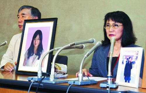 일본 최대 광고회사 덴쓰에 입사한지 얼마 안돼 과로에 시달리다 자살한 다카하시 마츠리의 부모가 2016년 10월 도쿄에서 딸의 사진을 내걸고 기자회견을 열고 있다. 다카하시는 2015년 12월 자살했지만 몇 달이 지난 뒤에야 사건이 알려졌다. AP뉴시스