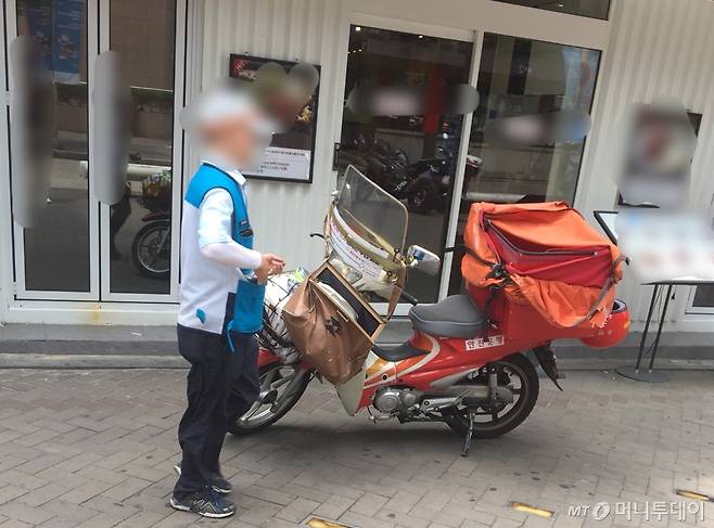 무더운 날씨에 오토바이를 타고 배달을 다니느라 분주해하던 우체국 집배원의 모습./사진=남형도 기자