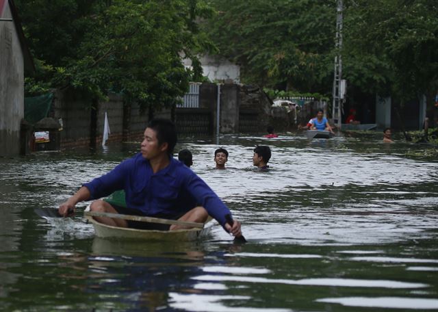 베트남  하노이의 치앙마이지구가 31일(현지시간)  몬순 폭우로 침수된 가운데 주민들이 수영을 하거나 보트를 타고 있다.  AP 연합뉴스