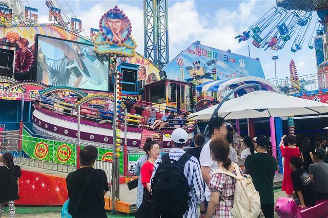 지난 5일 인천 중구 월미테마파크를 찾은 관람객들이 원형 놀이기구 ‘디스코팡팡’이 빙빙 돌아가는 모습을 바라보고 있다.