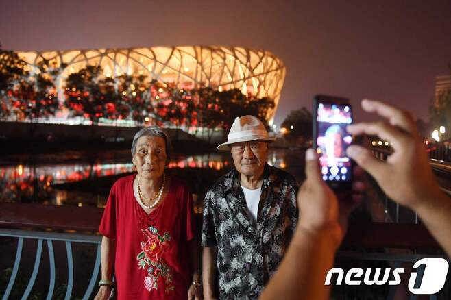 베이징 올림픽 메인 스타디움. 중국인 노부부가 메인 스타디움을 배경으로 사진을 찍고 있다. © AFP=뉴스1 © News1