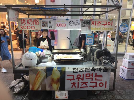 서울 명동 거리에서 팔리고 있는 치즈 구이. 이 신개념 K푸드는 꼬치에 꽃은 국내산 치즈와 떡을 구은 뒤 연유에 찍어 내놓는다. 남정호 기자