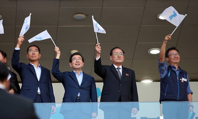 11일 오후 서울월드컵경기장에서 열린 남북노동자통일 축구대회에서 김명환 민주노총 위원장(왼쪽부터), 박원순 서울시장, 조선직업총동맹 주영길 위원장, 김주영 한국노총 위원장이 한반도 단일기를 흔들고 있다. 연합뉴스