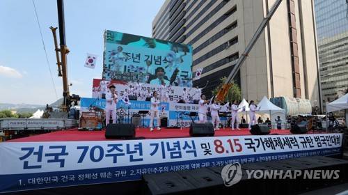 보수단체, 건국 70주년 행사 (서울=연합뉴스) 한상균 기자 = 광복절을 맞은 15일 오전 광화문 광장 인근에서 보수단체들이 '건국 70주년 기념식 및 8.15 국가해체세력 규탄 범국민대회'를 하고 있다.       xyz@yna.co.kr  (끝)