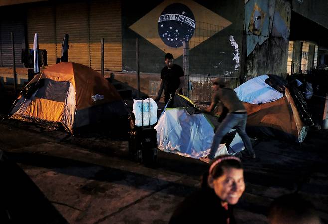 베네수엘라 남성이 지난 8일 브라질 호라이마주 파카라이마시의 한 길거리에서 숙소로 쓸 텐트를 치고 있다. 파카라이마|로이터연합뉴스