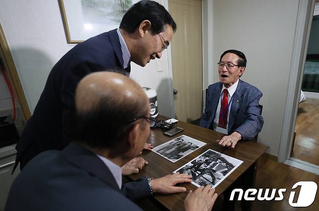 제21차 이산가족 상봉을 하루 앞둔 19일 오후 강원도 속초시 한화리조트에서 남측 1차 상봉 대상자인 윤흥규(92) 할아버지가 조명균 통일부 장관과 박경서 대한적십자사 회장에게 자신의 군복무 시절 사진을 보여주고 있다. 2018.8.19/뉴스1 © News1 뉴스통신취재단