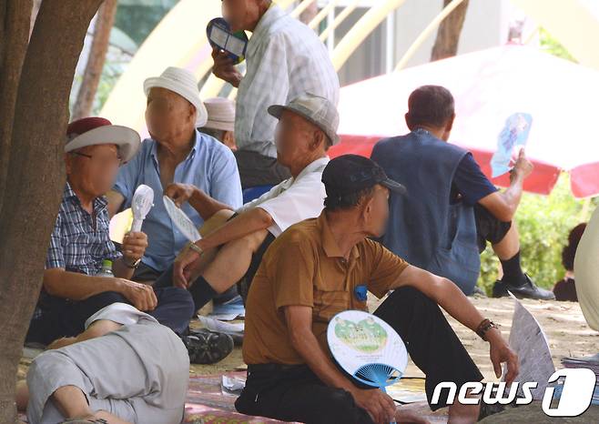 무더위가 이어진 25일 오후 1시쯤 청주시 상당구 중앙공원 나무그늘에 노인들이 모여 더위를 피하고 있다. © News1 박태성 기자