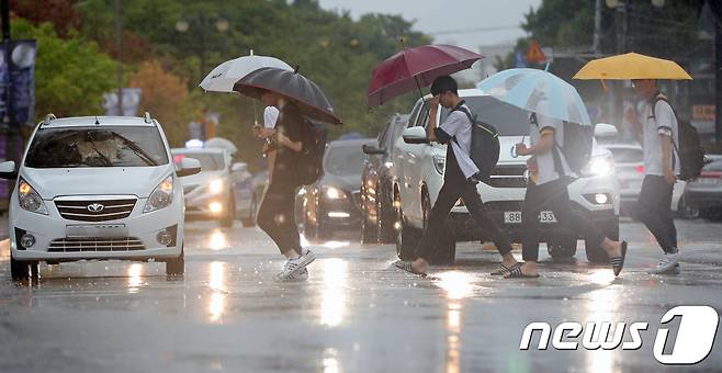 제19호 태풍 '솔릭'이 북상하고 있는 23일 오후 전북 전주시 전북대학교 앞에서 학생들이 우산으로 비를 피하며 길을 건너고 있다. 기상청은 태풍 '솔릭'이 전남 영광 부근에 상륙할 가능성이 높다고 예보했다.2018.8.23/뉴스1 © News1 문요한 기자