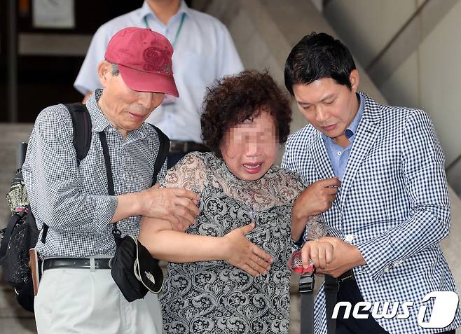 24일 오전 서울 서초구 서울중앙지법에서 열린 '592억 뇌물' 등 항소심 선고공판에서 한 지지자가 선고 결과를 듣고 오열하고있다. 서울고법 형사4부는 박 전 대통령에 대해 징역 24년과 벌금 180억원을 선고한 원심을 파기하고 징역 25년과 벌금 200억원을 선고했다. 2018.8.24/뉴스1 © News1 이재명 기자