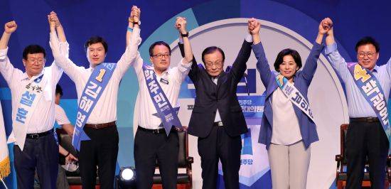 박주민 의원(왼쪽 세번째)이 26일 서울 송파구에서 열린 더불어민주당 전당대회에서 득표율 1위로 최고위원에 선출된 뒤 최고위원 선출자들, 이해찬(가운데) 민주당 대표와 함께 손을 들어올리고 있다. 뉴시스