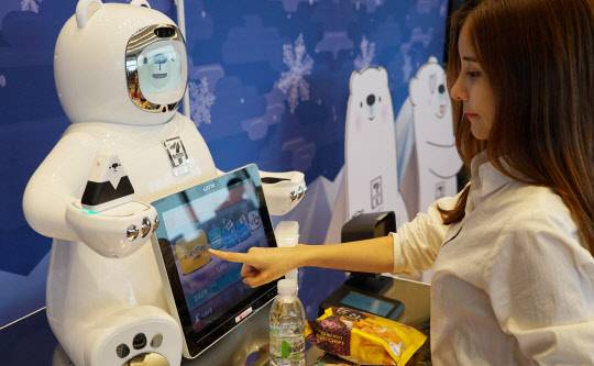 28일 오전 서울 롯데월드타워 세븐일레븐 시그니처점에서 모델이 '세계 최초 핸드페이 탑재 인공지능 결제 로봇 브니(VENY)'를 이용하여 결제 시연을 하고 있다. <사진=세븐일레븐 제공>