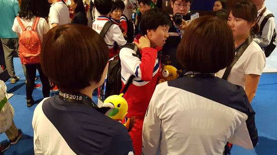 28일 열린 자카르타 팔렘방 아시안게임 탁구 여자 단체전에서 대화를 나누는 북한의 김송이(가운데)와 한국 탁구 선수들. 자카르타=김지한 기자