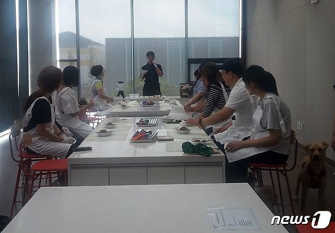 원범식 디자이너가  반려견 수제간식 만드는 방법을 알려주고 있다.  위생장갑과 앞치마도 제공했다.  © News1