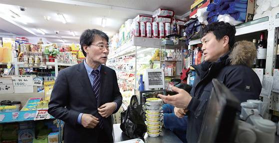 장하성 청와대 정책실장(왼쪽)이 1월 18일 오전 최저임금 관련 소상공인 의견 청취 및 일자리 안정자금 홍보를 위해 서울 관악구 신림사거리 일대 상점가를 방문해 상인들과 대화를 나누고 있다. [연합뉴스]