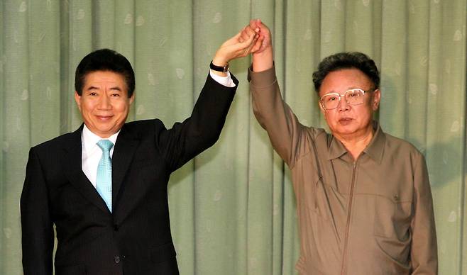 2007년 10월 4일 노무현 대통령과 김정일 국방위원장이 백화원 영빈관에서 열린 정상회담에서 선언문에 서명한 뒤 맞잡은 손을 들어 올리고 있다. [중앙포토]