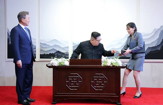 문재인 대통령이 지난 4월 27일 오전 파주시 판문점 평화의 집에서 남북정상회담에 앞서 방명록을 쓰는 북한 김정은 국무위원장을 보고 있다. 오른쪽은 만년필을 건네는 김여정 당중앙위 제1부부장. [중앙포토]