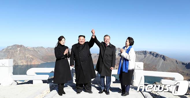 20일 오전 문재인 대통령과 김정은 북한 국무위원장이 백두산 정상인 장군봉에 올라 손을 맞잡아 들어 올리고 있다. 김정숙 여사와 리설주 여사도 함께 했다.2018.9.20/뉴스1 © News1 평양사진공동취재단