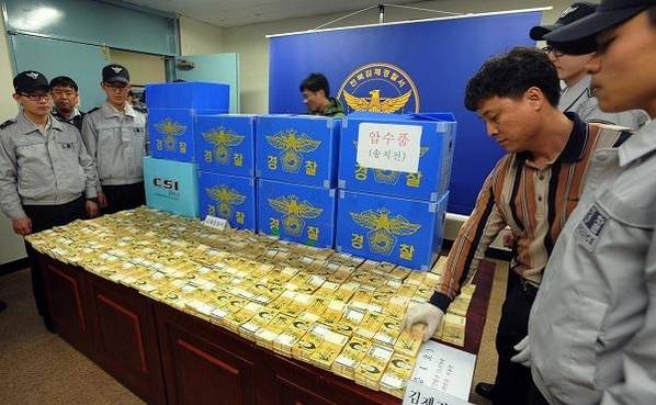 2011년 4월 전북 김제시 금구면 선암리 마늘밭에서 발견된 110억원 중 20억원을 전북김제경찰서 수사관들이 펼쳐 보이고 있다./ 조선일보 DB