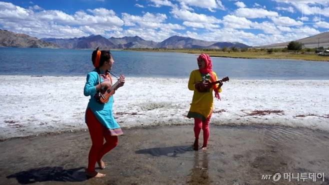 호숫가에서 우쿨렐레를 연주하고 있는 위경은(왼쪽), 김연우씨./사진=김연우, 위경은씨 제공