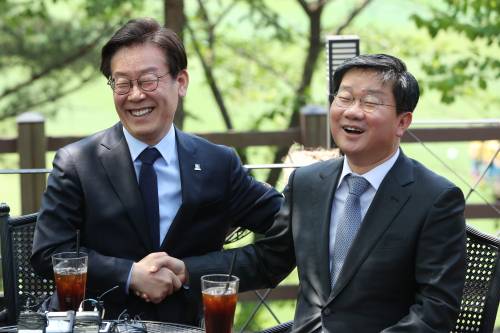 지난 4월 당시 더불어민주당 이재명 경기도지사 후보(왼쪽)가 경선에 함께했던 전해철 의원을 만나 함께 웃으며 대화하고 있다.