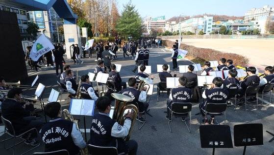 14일 오전 서울 서초구 서울고등학교에서 열린 수능장도식에서 고3 수험생들이 관악반 후배들의 연주 응원을 받으며 학교를 나서고 있다. [연합뉴스]