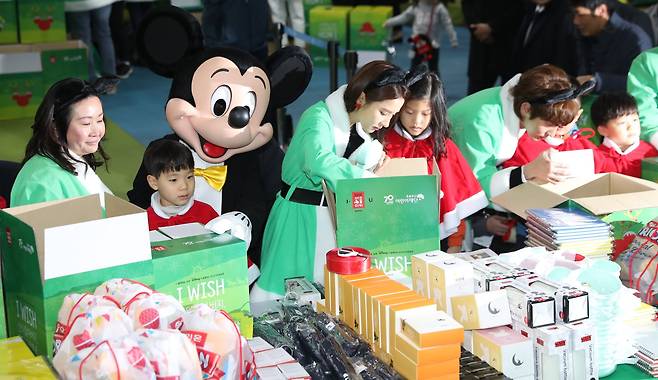 28일 오전 서울시민청에서 열린 '2018 산타원정대' 크리스마스 선물포장 행사에서 한국에 첫 방문한 미키마우스와 배우 이준기, 신세경을 비롯한 참석자들이 선물포장을 하고 있다. 우상조 기자