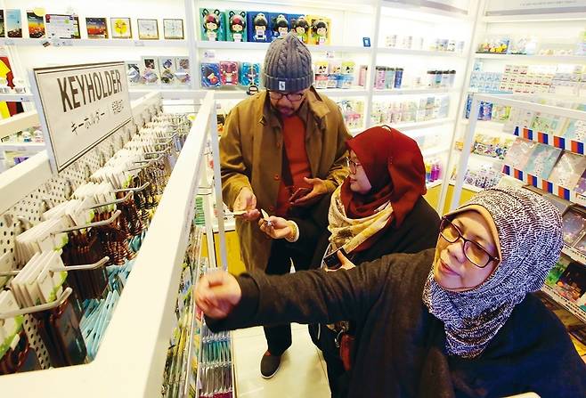 지난 28일 점심 남산에 있는 N서울타워 1층 관광기념품 가게에서 인도네시아 가족 관광객이 서울 여행 기념품을 고르고 있다.