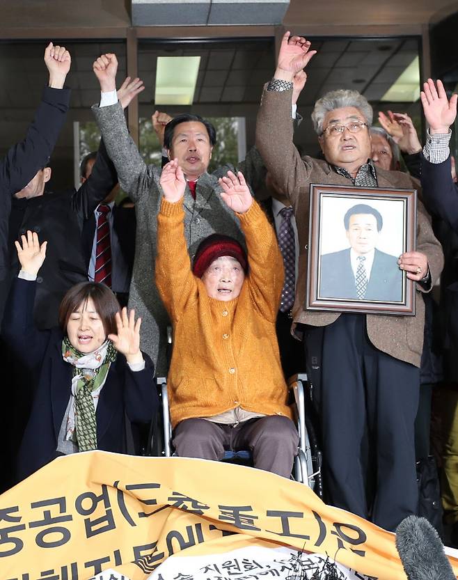 29일 오전 서울 서초구 대법원 대법정 앞에서 일제 강제징용 피해자 및 가족들이 미쓰비시 중공업 상대로 낸 손해배상청구 청구소송 상고심에서 승소한 뒤 기자회견을 하며 만세를 외치고 있다. 연합뉴스