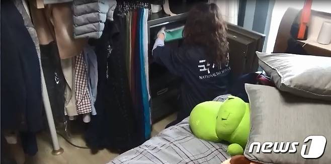 국세청 조사관이 체납자의 안방금고에 숨겨진 골드바 등 은닉재산을 찾고 있다.(국세청 제공)© News1
