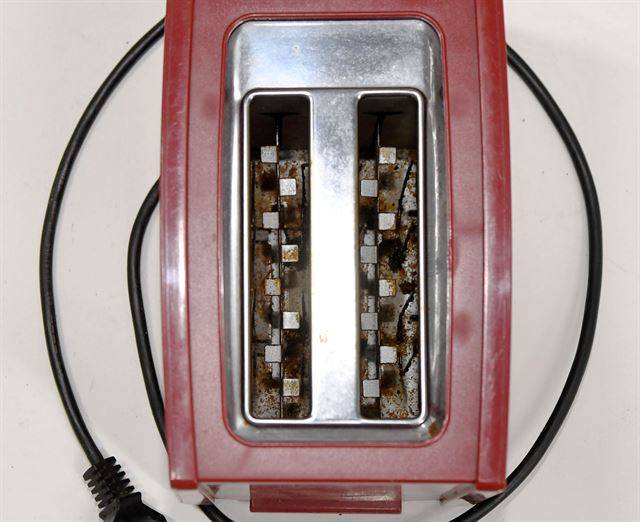 기기 내부에 각종 이물질과 녹이 가득한 토스터기.