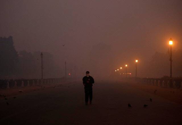 11월 8일(현지시간) 인도의 수도 뉴델리에서 마스크를 쓴 한 남성이 미세먼지로 뒤덮인 전승 기념물 인디아 게이트를 지나가고 있다. /뉴델리=로이터연합뉴스