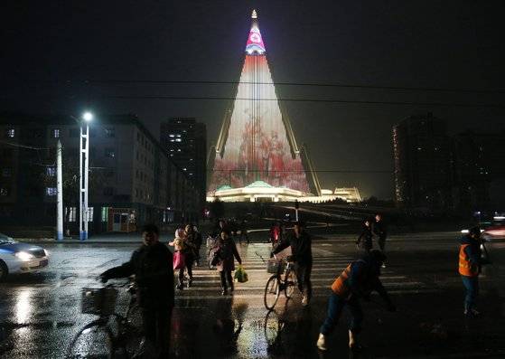 평양 시민들이 지난 18일 LED 조명으로 빛나는 류경호텔 앞을 지나고 있다. [AP=연합뉴스]
