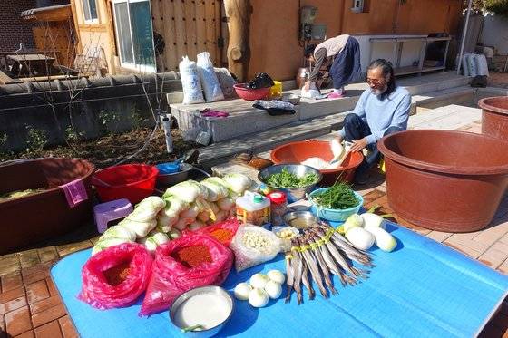박종대씨가 김장 소에 들어갈 무를 채 치고, 이혜경씨는 믹서에 양념을 갈고 있다. 앞에 늘어놓은 것은 절인 배추와 김칫소에 들어갈 재료들이다.