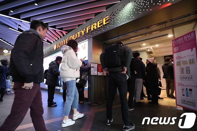 지난달 23일 서울 중구 롯데면세점 명동본점에서 쇼핑객들이 승강기를 타기 위해 줄을 서 있다. 2018.12.23/뉴스1 © News1 신웅수 기자