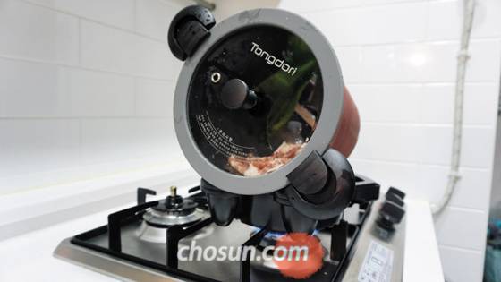 헨즈 통돌이 오븐으로 고기를 굽고 있는 모습. 가스레인지 위에 받침대를 올리고 냄비를 놓아두면 냄비가 저절로 한 방향으로 회전한다. /조재희 기자