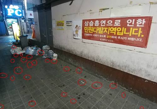 상가 옆 골몰길. '상습흡연으로 인한 민원 다발지역입니다. 간접흡연의 피해가 없도록 금연하여 주시길 바랍니다.'라는 경고문이 선명하게 붙어있지만, 경고문 아래에는 버려진 각종 쓰레기와 담배꽁초가 수북이 쌓여있었다.