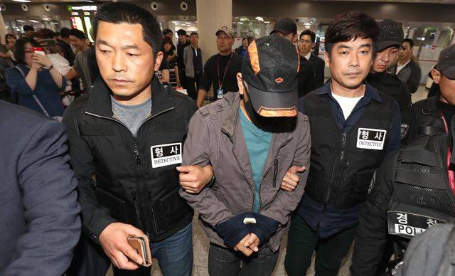 2018년 5월 제주 보육교사 살인사건의 피의자 박모씨(가운데 모자 쓴 이)가 경북 영주에서 체포돼 경찰서로 압송됐다. 연합뉴스