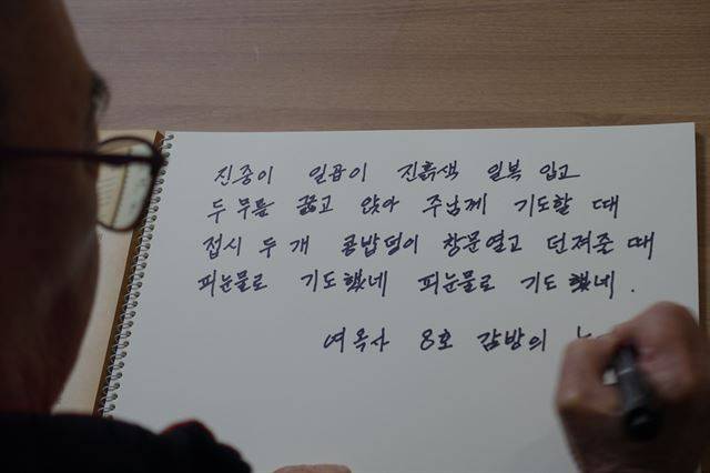 심명철 지사의 아들 문수일씨가 어머니에게서 들었던 ‘8호 감방’의 노래 가사를 써내려 가고 있다. 이진희 기자