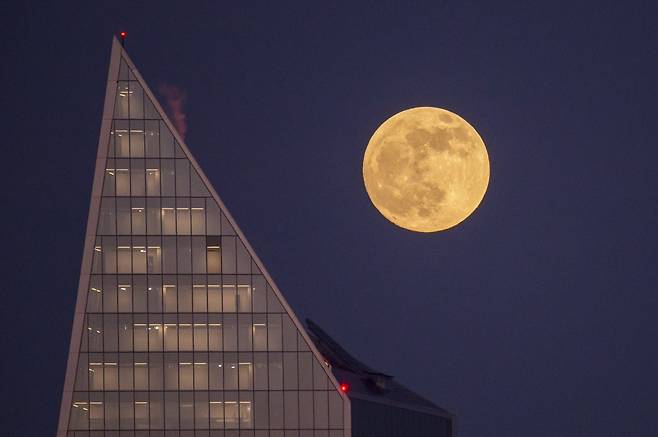 21일(현지시간) 영국 런던의 초고층 빌딩 위에 떠 있는 수퍼문. [신화=연합뉴스]