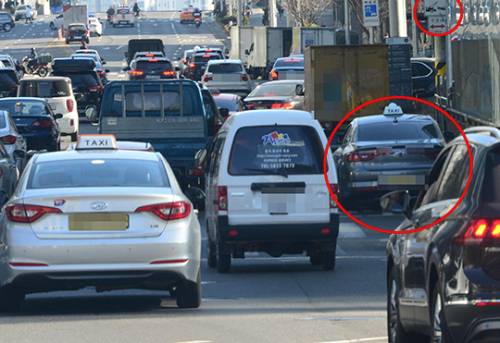 불법 주정차 된 차들이 차량 흐름을 방해하고 있다