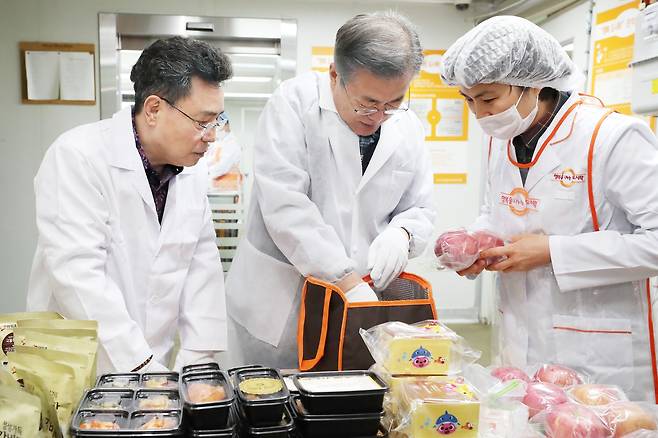 문재인 대통령이 1일 오전 서울 관악구 행복도시락 사회적협동조합 관악센터에서 최영남 나눔공동체 대표와 함께 도시락 포장을 하고 있다.[사진 청와대]