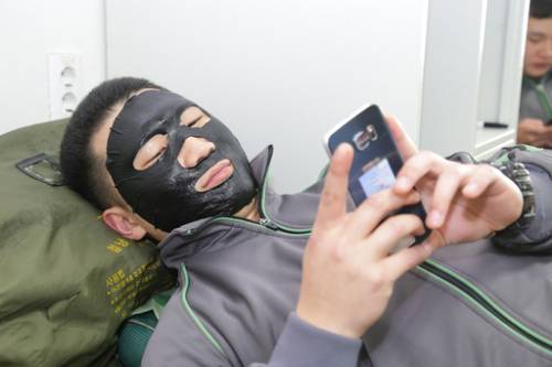 육군 청성부대 소속 병사가 지난달 31일 부대 내 생활관에서 마스크팩을 얼굴에 씌운 채 휴대전화를 사용하며 휴식을 취하고 있다. 육군 제공