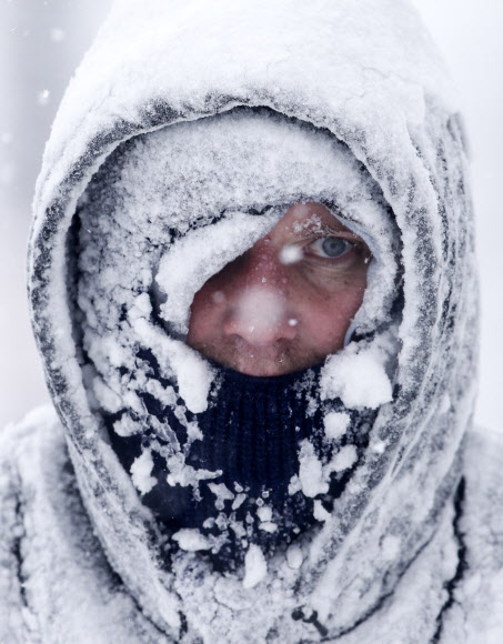 지난 1월 28일 북극진동으로 인해 미국 중북부 위스콘신주 매니토웍에 눈폭풍과 혹한이 몰아친 가운데 한 주민이 집 앞 진입로의 눈을 치우기 위해 나왔다가 눈으로 뒤덮여 얼어붙은 모습.AP연합